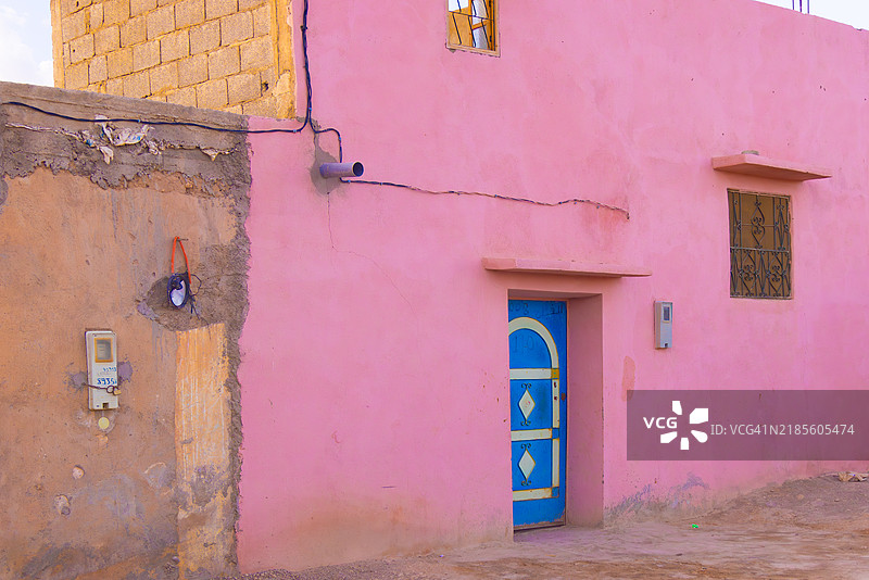 摩洛哥阿加法伊沙漠中的鲜艳粉色房屋与蓝色门图片素材