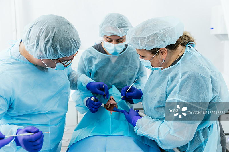 牙医在牙科诊所为患者进行口腔手术图片素材