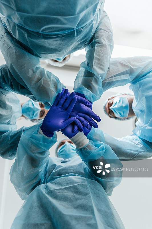 手术室内，医疗团队在手术前握手。图片素材