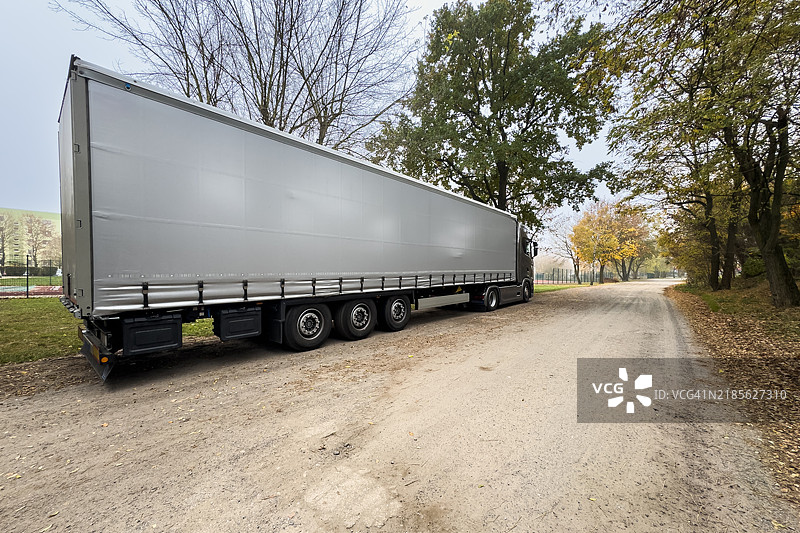 一辆大型卡车停在一条肮脏的道路上图片素材