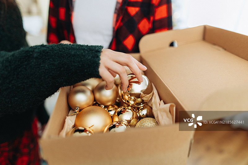 女人的手从盒子里拿出一个圣诞球图片素材