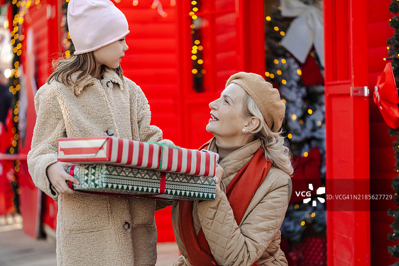 微笑的老年女性与孙女在城市中享受圣诞节的时光图片素材
