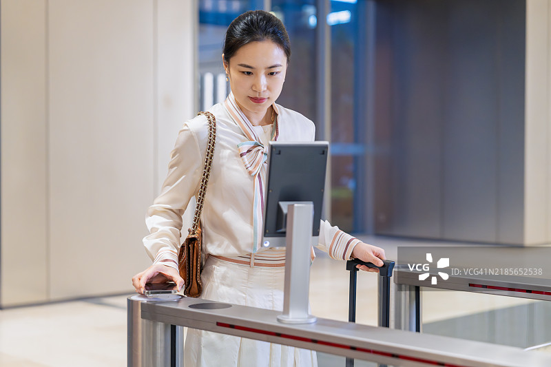 亚洲商务人士使用面部识别技术打开办公大楼的门禁系统图片素材