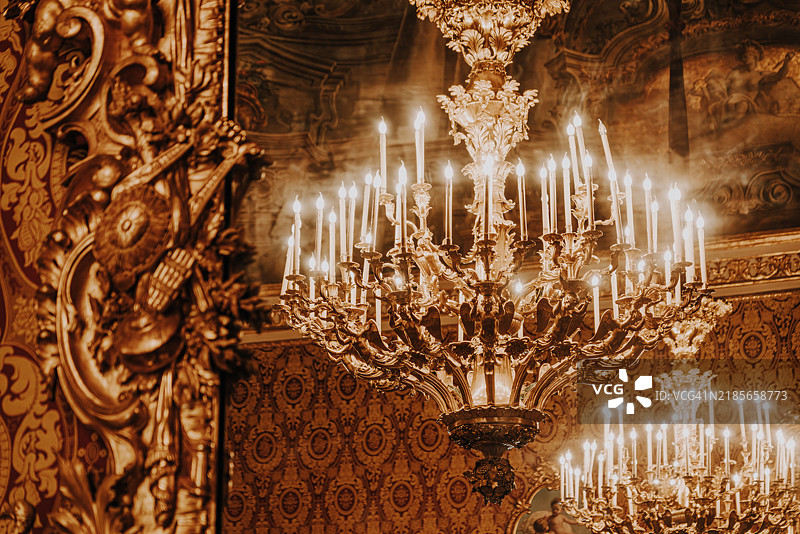 奢华的金色吊灯照亮华丽的巴洛克风格房间装饰图片素材