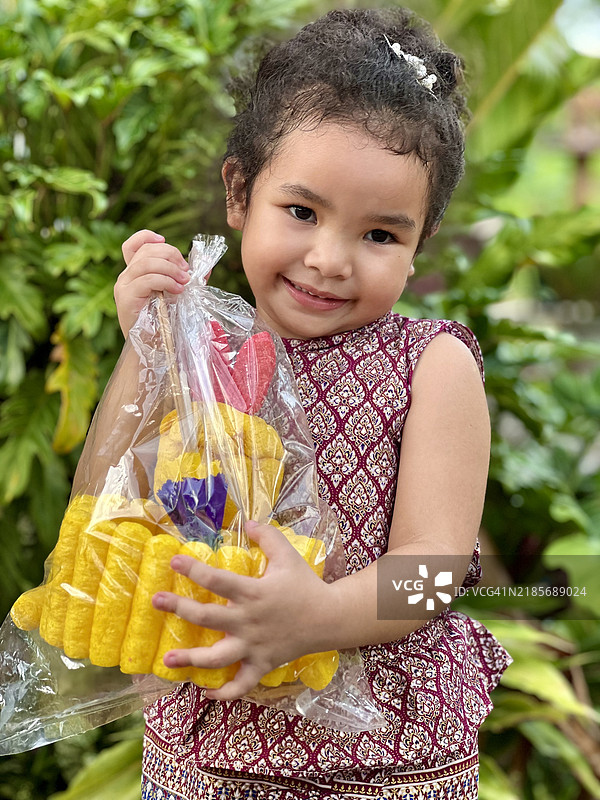 亚洲小女孩穿着泰国服装，在水灯节上手持面包水灯。图片素材
