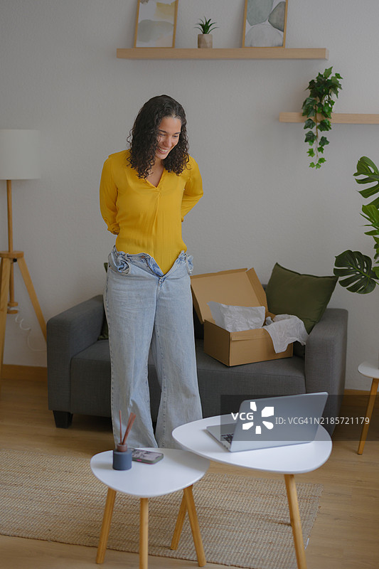 快乐的女性成功减肥后穿上旧牛仔裤图片素材