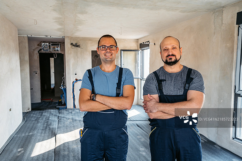 两名电工站在正在装修的空公寓里图片素材
