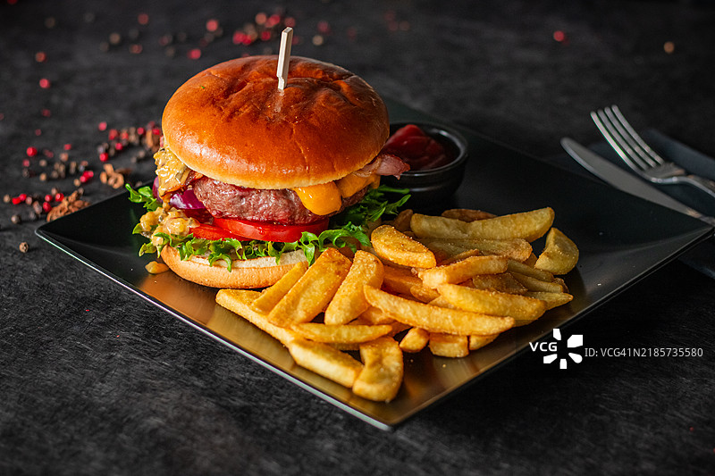 一份多汁的汉堡，配有生菜、西红柿、奶酪和洋葱图片素材
