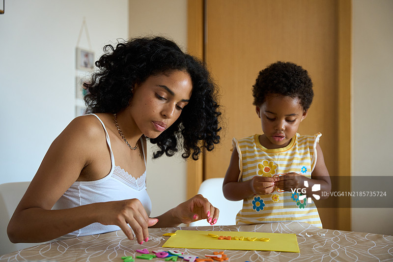 母女在家用彩色字母创作艺术作品图片素材