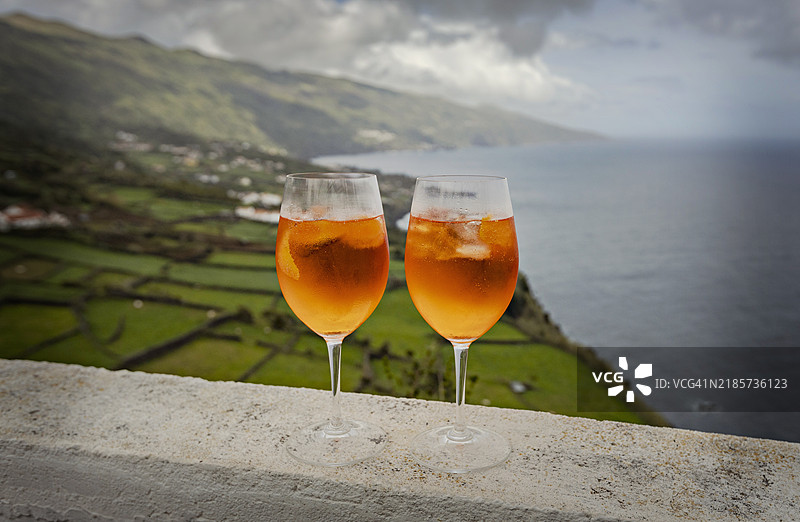两杯阿佩罗鸡尾酒与海洋景观相映成趣图片素材