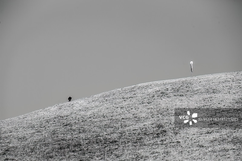 低角度视图的男子站在山上，背景是天空，加利福尼亚州米尔皮塔斯，美国图片素材