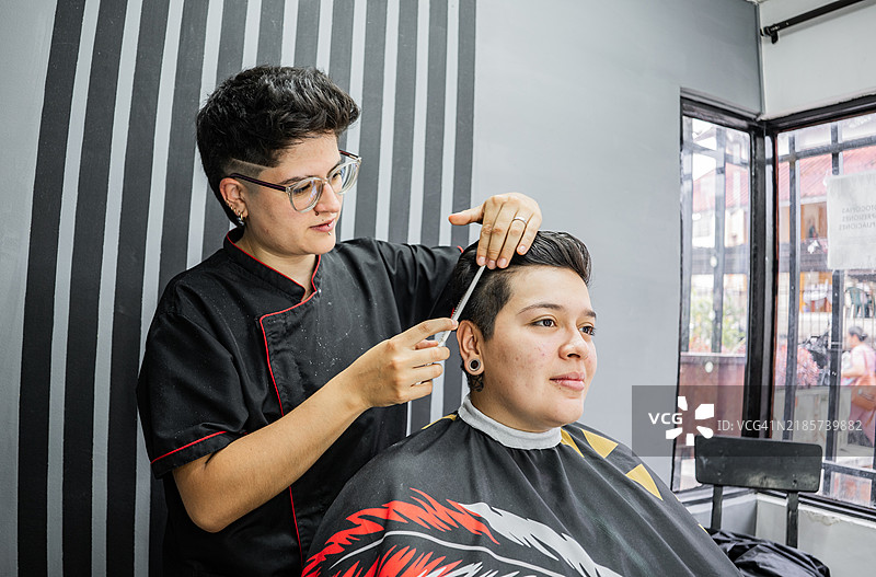 理发师在理发店为顾客梳头发图片素材