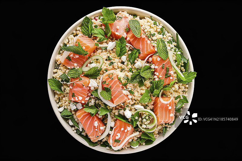 色彩鲜艳、令人垂涎的沙拉菜肴，包含与切片三文鱼混合的库斯库斯。图片素材