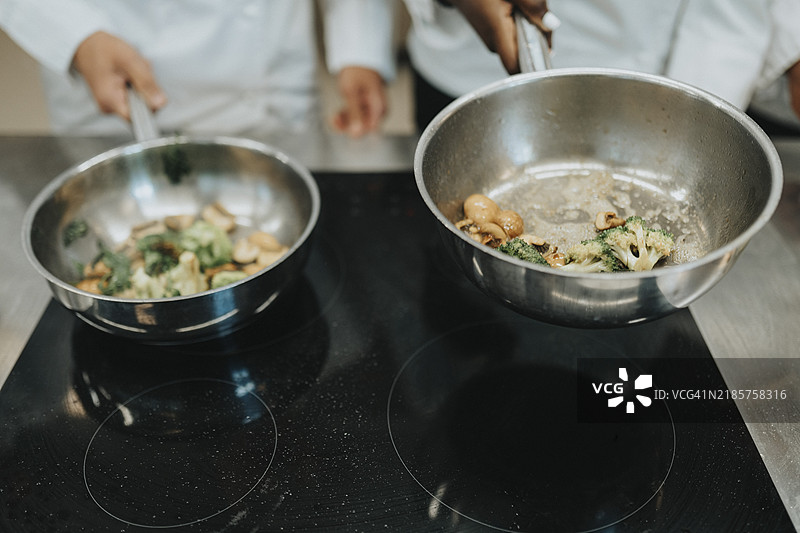 厨师在平底锅中准备食物的特写镜头图片素材