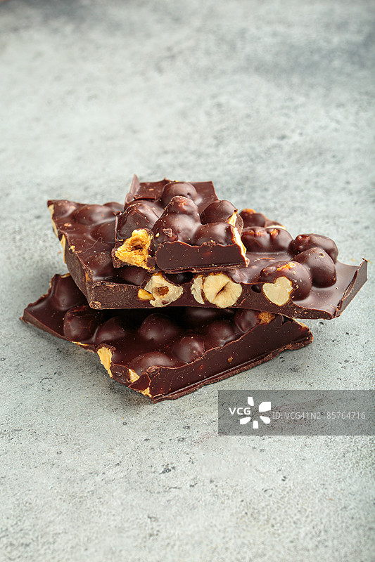 黑巧克力与榛子块静静地放在灰色表面上图片素材