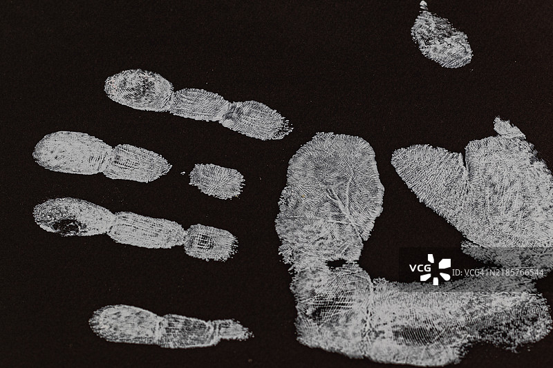 黑色纸板上人类男性手印的斜视图图片素材