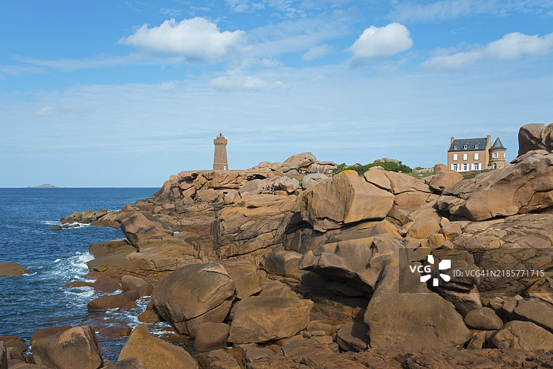 海岸上的雄伟岩石,远处有灯塔和房屋,梅鲁兹灯塔和古斯塔夫·埃菲尔之家,普洛曼纳赫,斯奎维尔角,佩罗吉雷克,粉红花岗岩海岸,粉红花岗岩海岸,布列塔尼,法国,欧洲图片素材