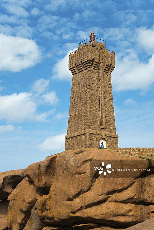 高耸的灯塔矗立在巨石上，背景是蓝天和白云，梅鲁兹灯塔，普洛曼阿赫，斯奎维尔角，佩罗-吉雷克，粉色花岗岩海岸，粉红花岗岩海岸，布列塔尼，法国，欧洲图片素材