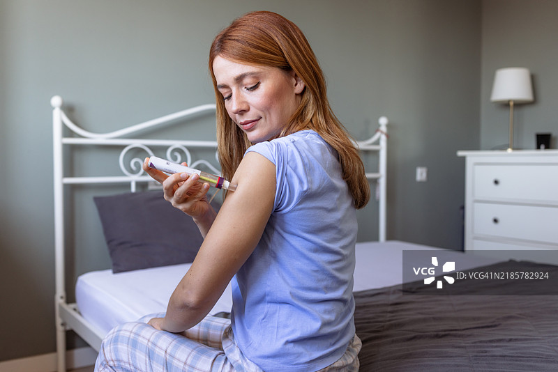 女性使用自注射笔进行骨病生物治疗图片素材