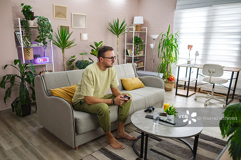 男人在家中的客厅玩电子游戏图片素材
