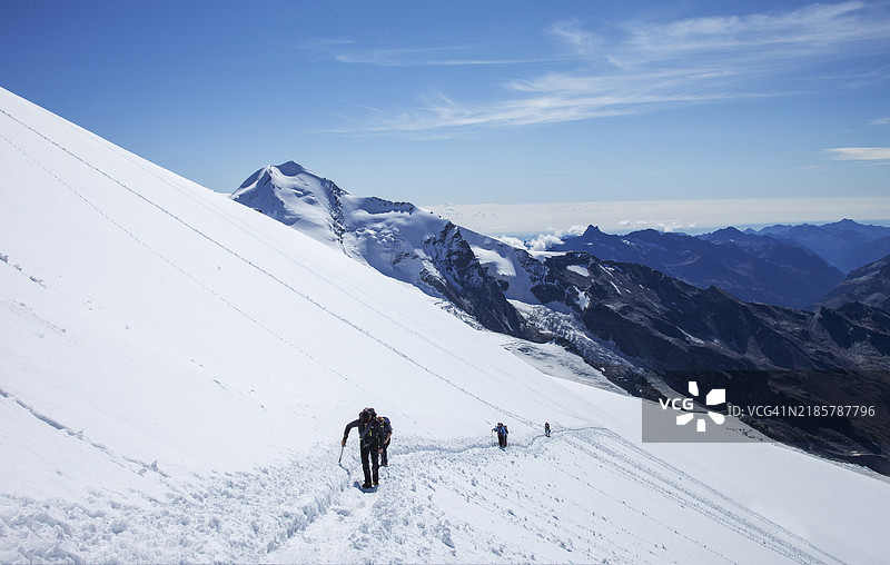 攀登者在雪坡上。图片素材