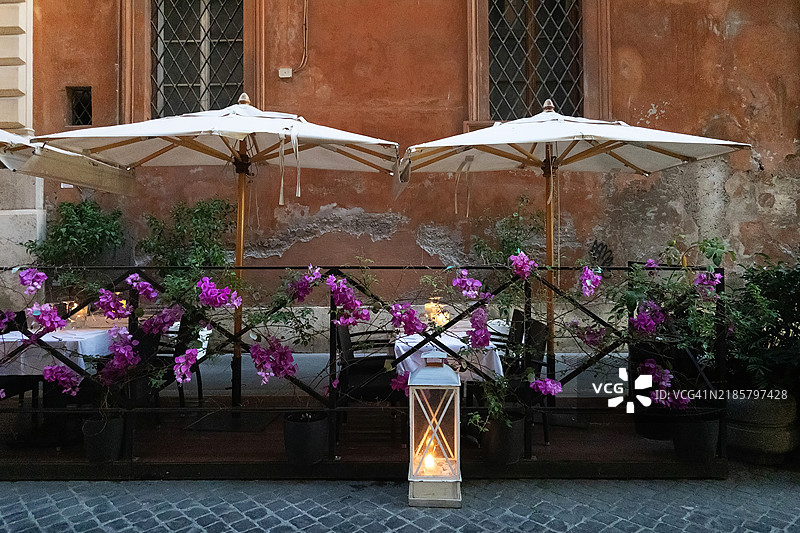 罗马人行道上的带遮阳篷的餐桌。图片素材