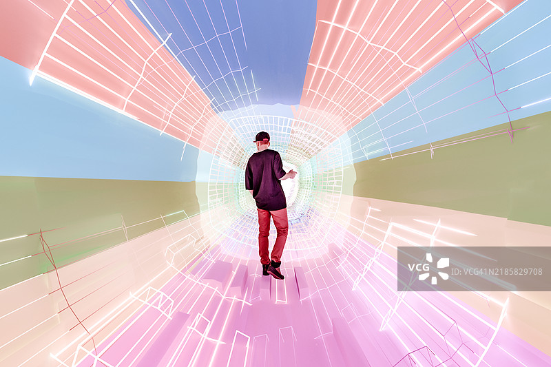 年轻男子站在抽象的虚拟现实走廊中图片素材