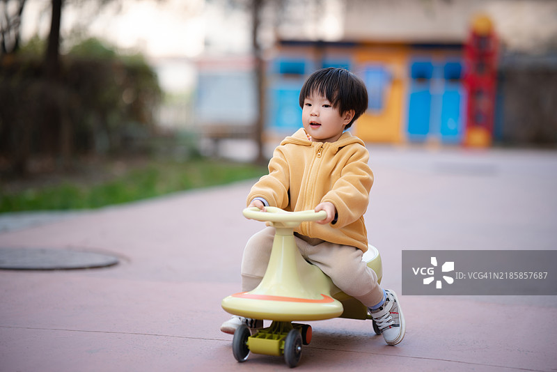 可爱的小女孩正在骑玩具自行车图片素材