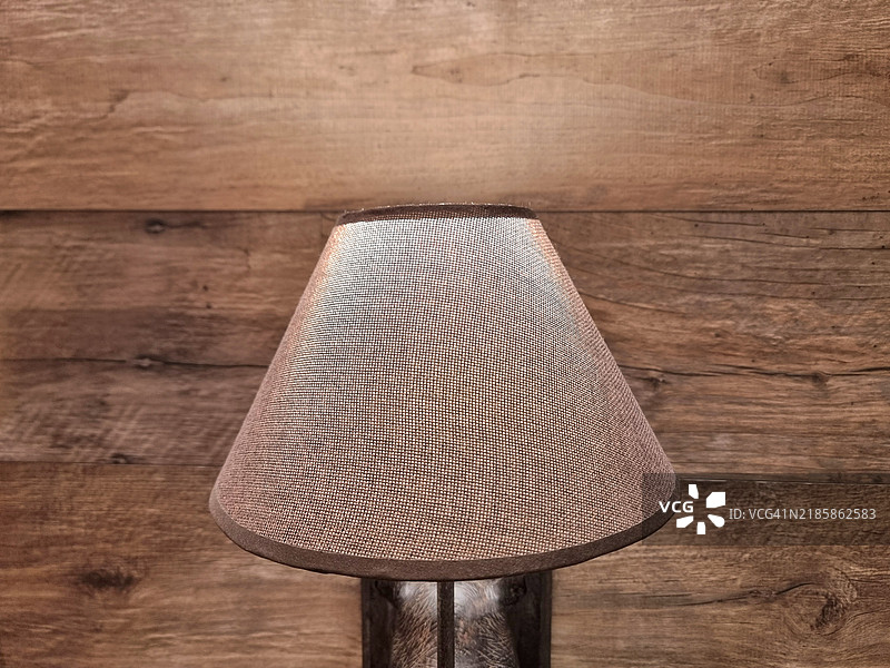 在意大利安科纳拍摄的照片，背景是一面木墙和一盏点亮的灯。这张照片是在室内家中拍摄的。安科纳，2024年11月。图片素材