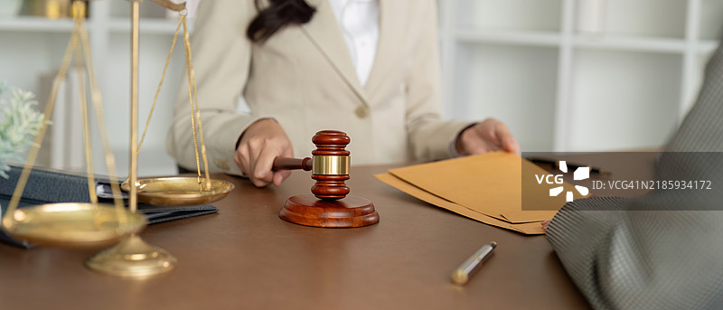 律师讨论法律案件，手持法槌和文件，专业场景图片素材