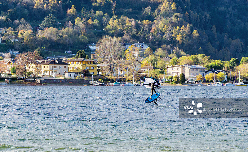 风是这个人的梦想，他在2024年11月的一个风天里，在意大利特伦蒂诺-阿尔托阿迪杰的卡尔多纳佐湖上用翼帆冲浪。图片素材