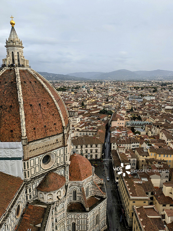 佛罗伦萨的鸟瞰图，杜莫大教堂和红色屋顶在阴云密布的天空下与远处的山丘相映成趣。意大利，欧洲图片素材