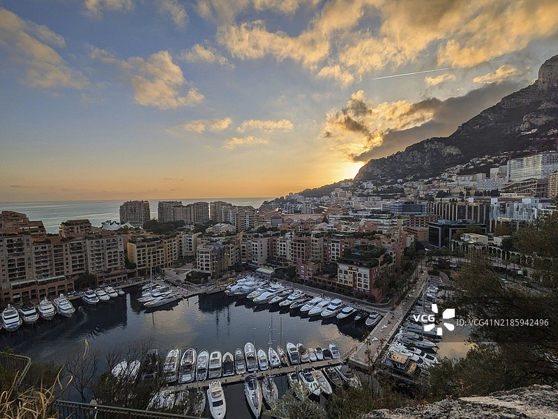 摩纳哥港口的美丽日落景色，游艇、建筑和壮观的天空。图片素材