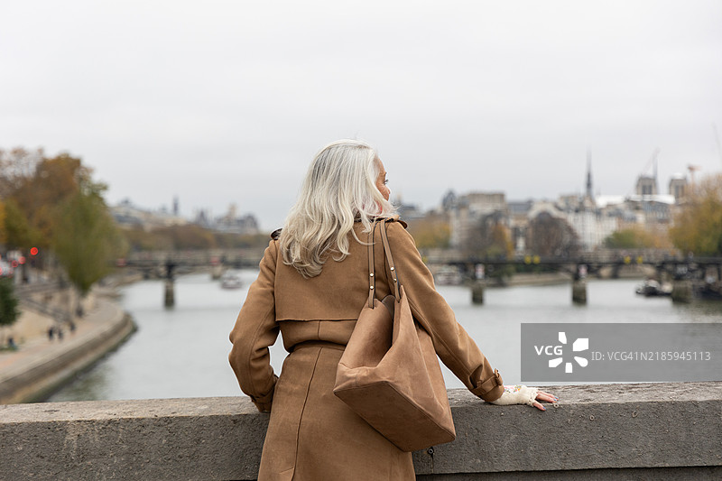 一位优雅的老年女性背影，欣赏城市风景图片素材