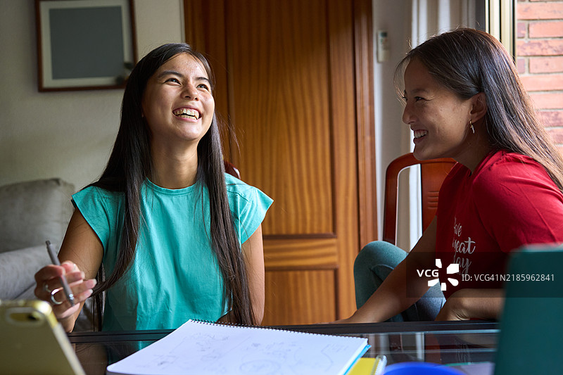 两个微笑的中国少女在家一起学习图片素材
