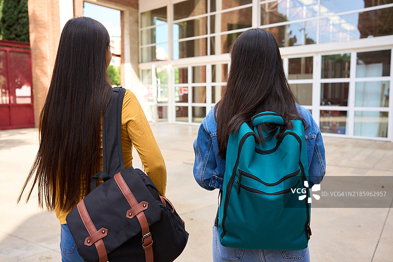 两个中国学生走出学校图片素材