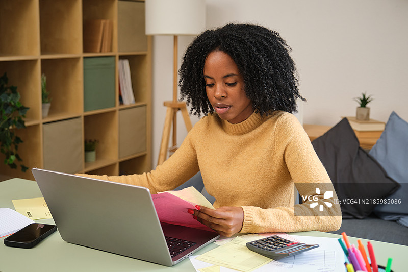 专注的会计师在家办公，使用笔记本电脑和文件管理财务图片素材