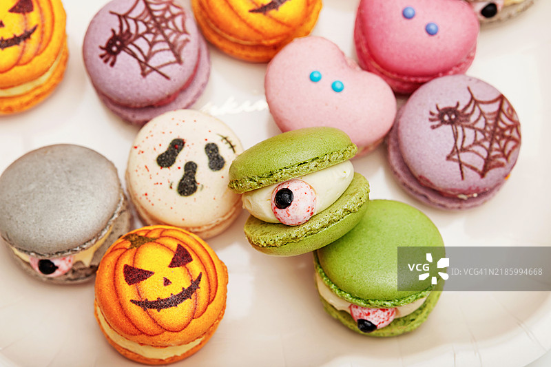 俯视一碗迷你万圣节马卡龙，上面有南瓜脸。图片素材