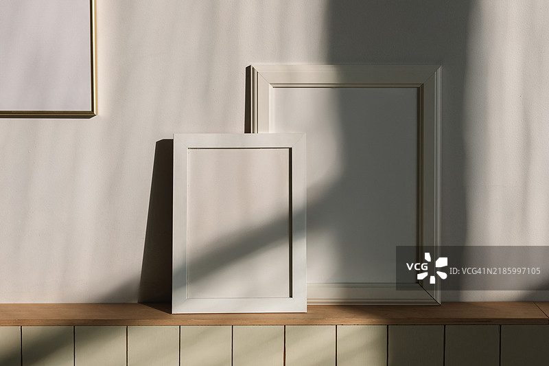 阳光下客厅架子上的空白相框特写图片素材