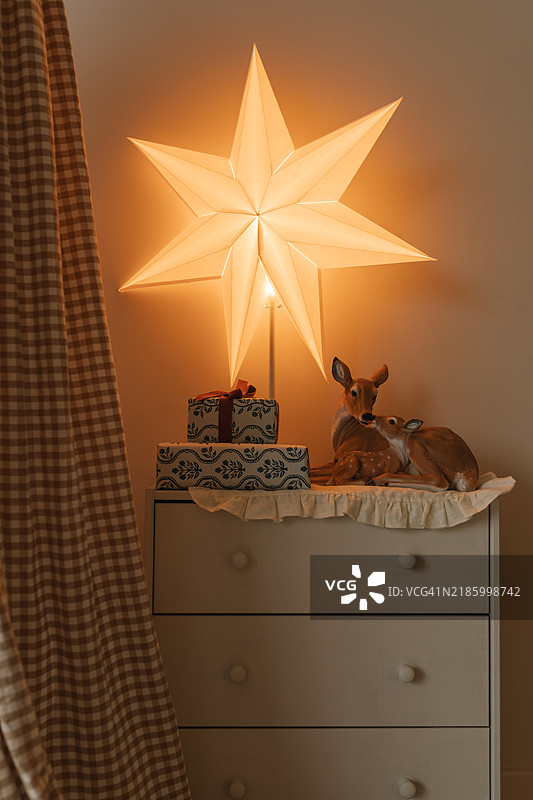卧室抽屉上的包裹礼物特写，星形灯饰和鹿形装饰品图片素材