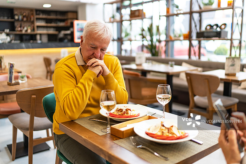 沮丧的老年男子与妻子共进午餐图片素材