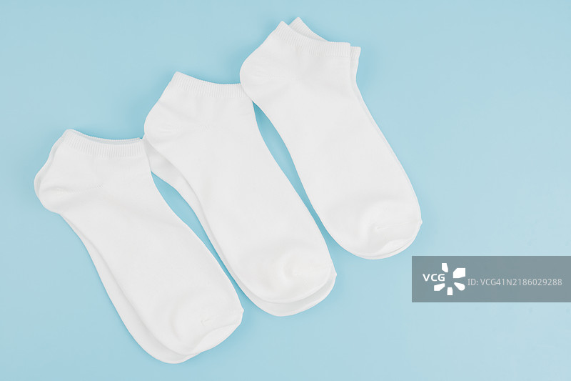 蓝色背景上的白色袜子，留有空白位置。图片素材