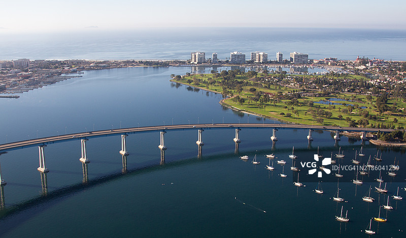 从空中俯瞰加利福尼亚州圣地亚哥的科罗纳多岛和格洛里埃塔湾，科罗纳多湾大桥横跨圣地亚哥湾。停泊在圣地亚哥湾的帆船。图片素材