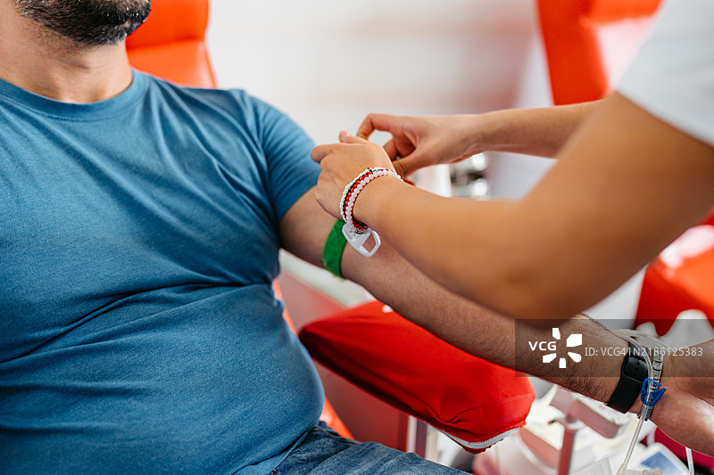 女护士在医院为男性病人抽血图片素材