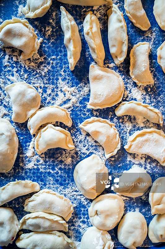 传统乌克兰饺子（varenyky）整齐地摆放在蓝色托盘上图片素材