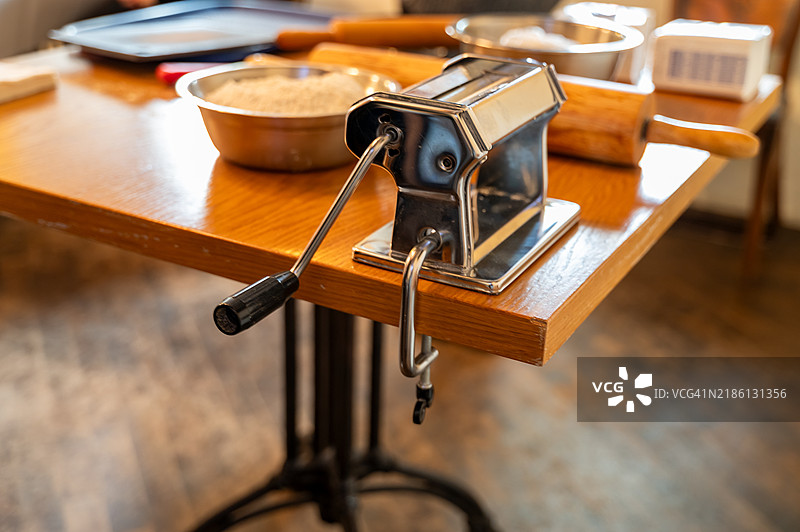 面团擀面机、面粉和擀面杖放在桌子上，准备制作面团图片素材