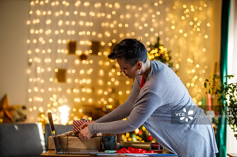 女性在节日气氛中包裹圣诞礼物图片素材
