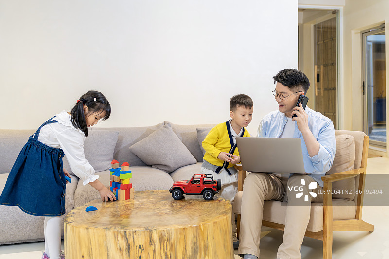 亚洲父亲在家工作图片素材