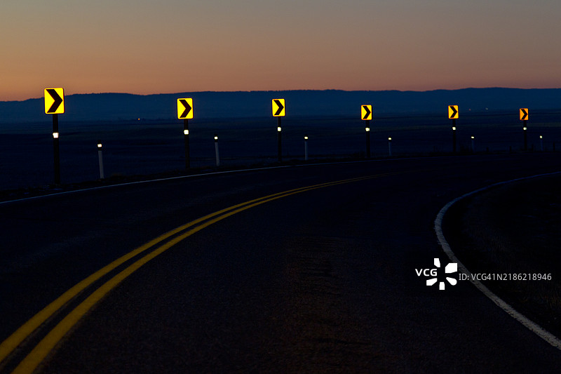 高速公路箭头标志被车灯照亮图片素材
