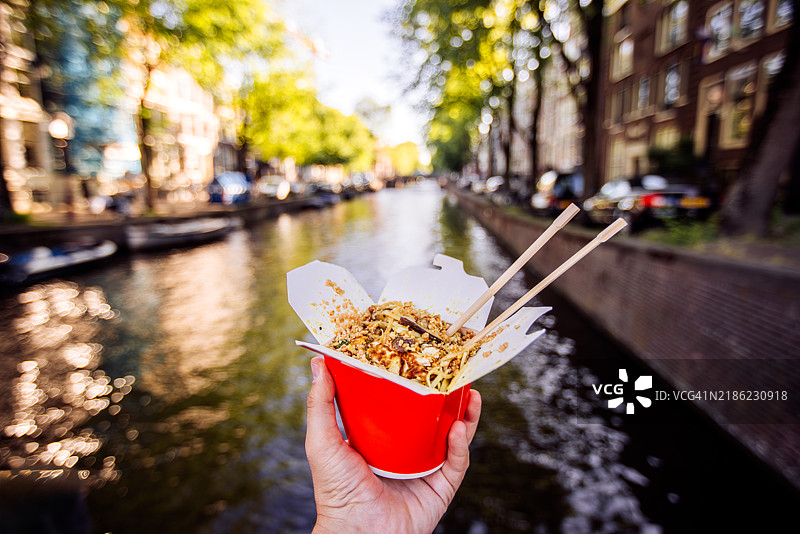 在阿姆斯特丹运河边享用中式外卖的个人视角，荷兰图片素材